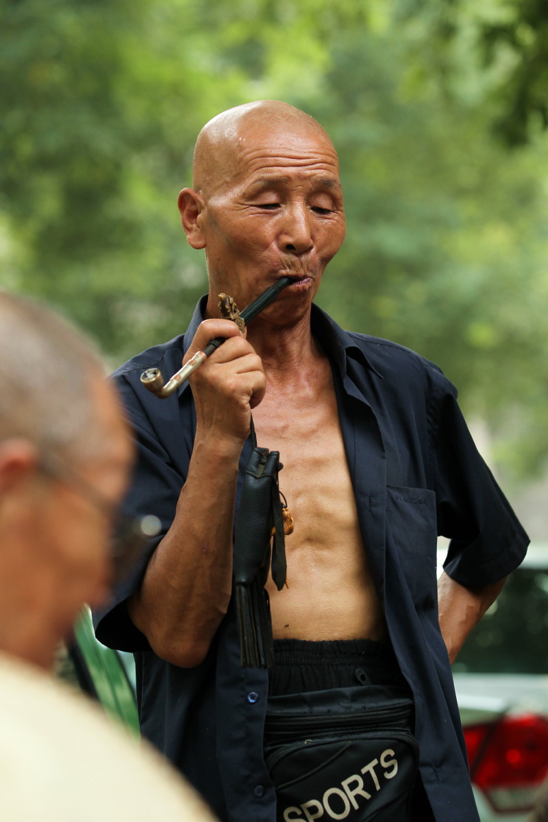 2013年的盛夏,西安城墙边,这位老汉悠闲地吸着旱烟,静静地看哥们儿在