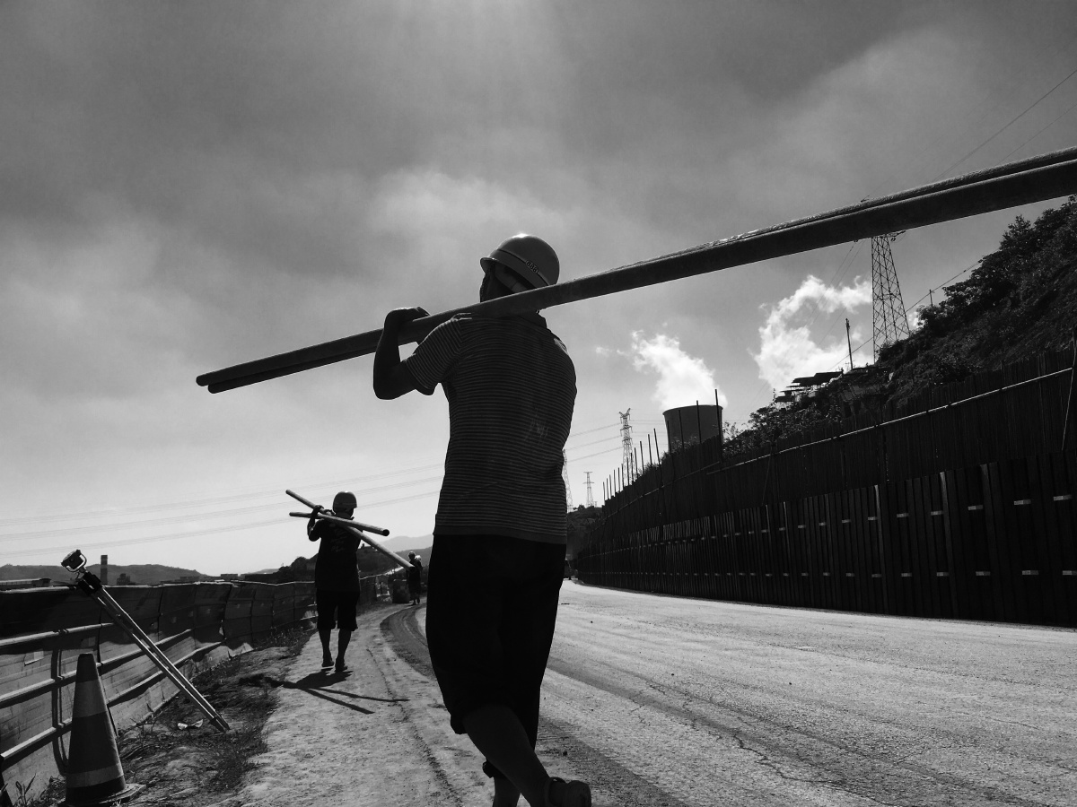 几个工人正在肩抗钢管.