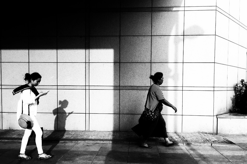 影儿墙上，人在影里，光影街道。