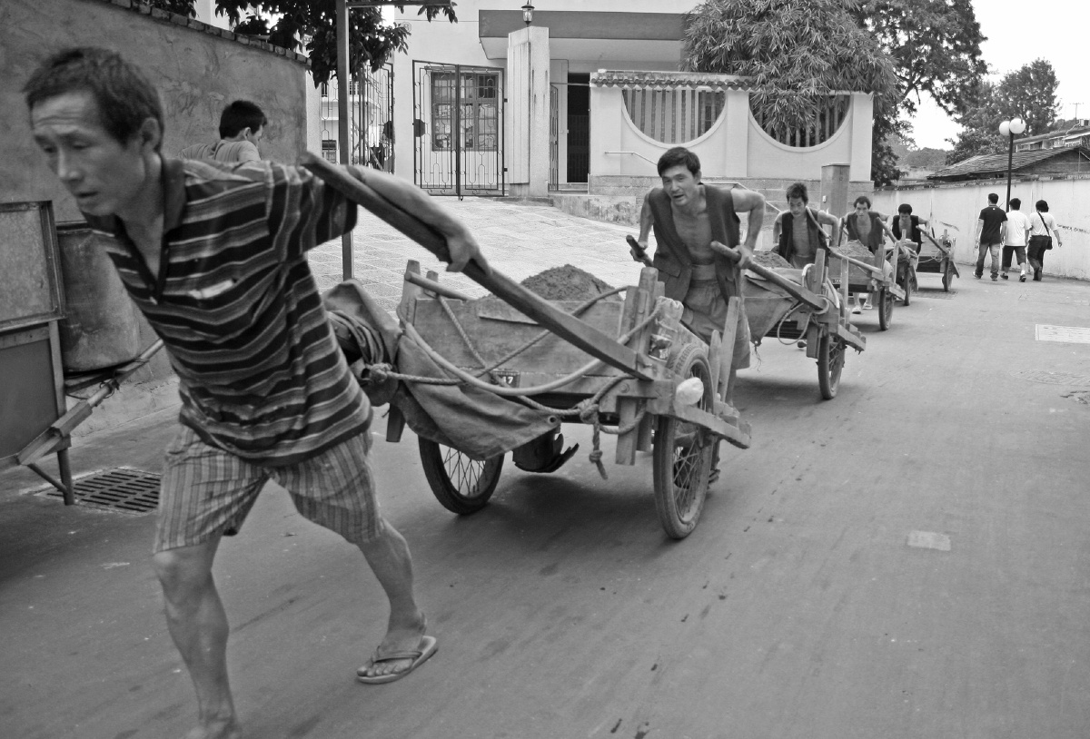 2008年10月25日,厦门鼓浪屿,板车工人成群拉着建筑材料爬坡.