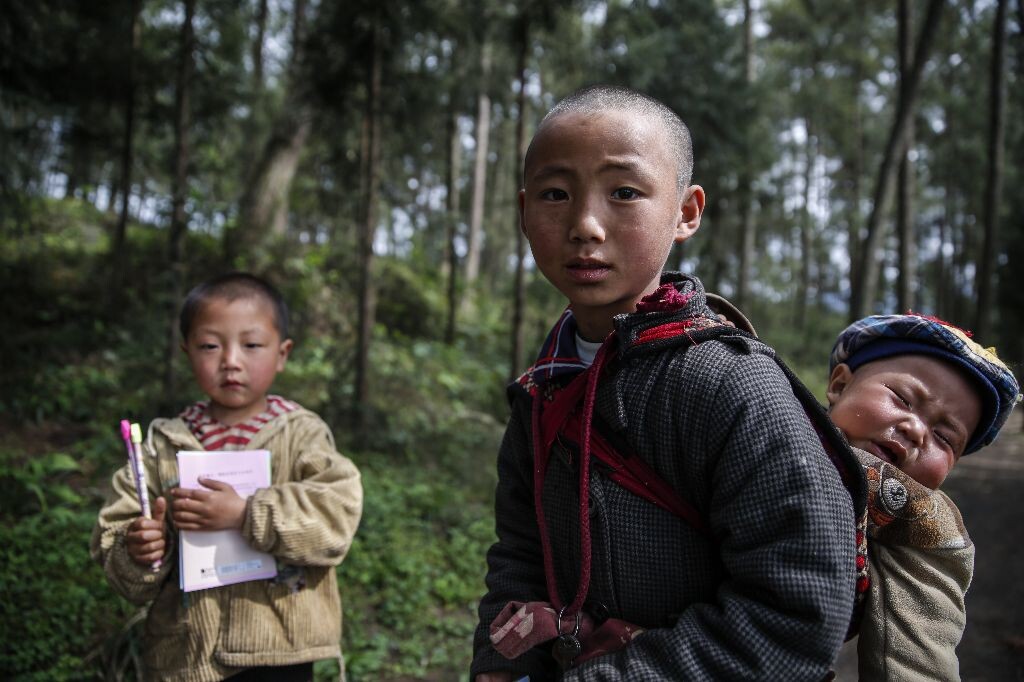 大人上山干农活了，只剩下哥哥照顾两个弟弟。哥哥已经11岁了，但一直没有上过学。有公益组织到村里做活动，二弟领了铅笔和本子，虽然他没有读过书，也没写过字，但看到其他的小孩去上学，他很是羡慕。