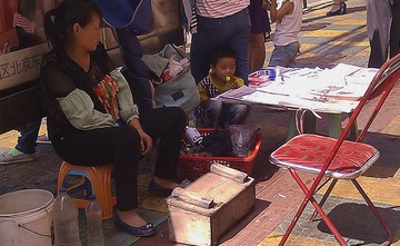 擦鞋兼售报纸还要照顾小孩