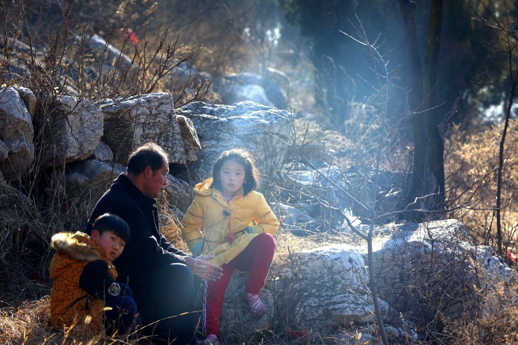 山里娃在山坡下等候在外打工归来的爸妈