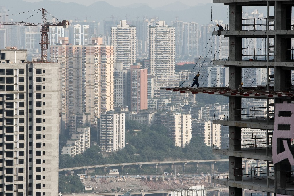 2009年7月,重庆江北区观音桥,工人在新建的楼盘上施工。重庆城市依山而建,错落有致。