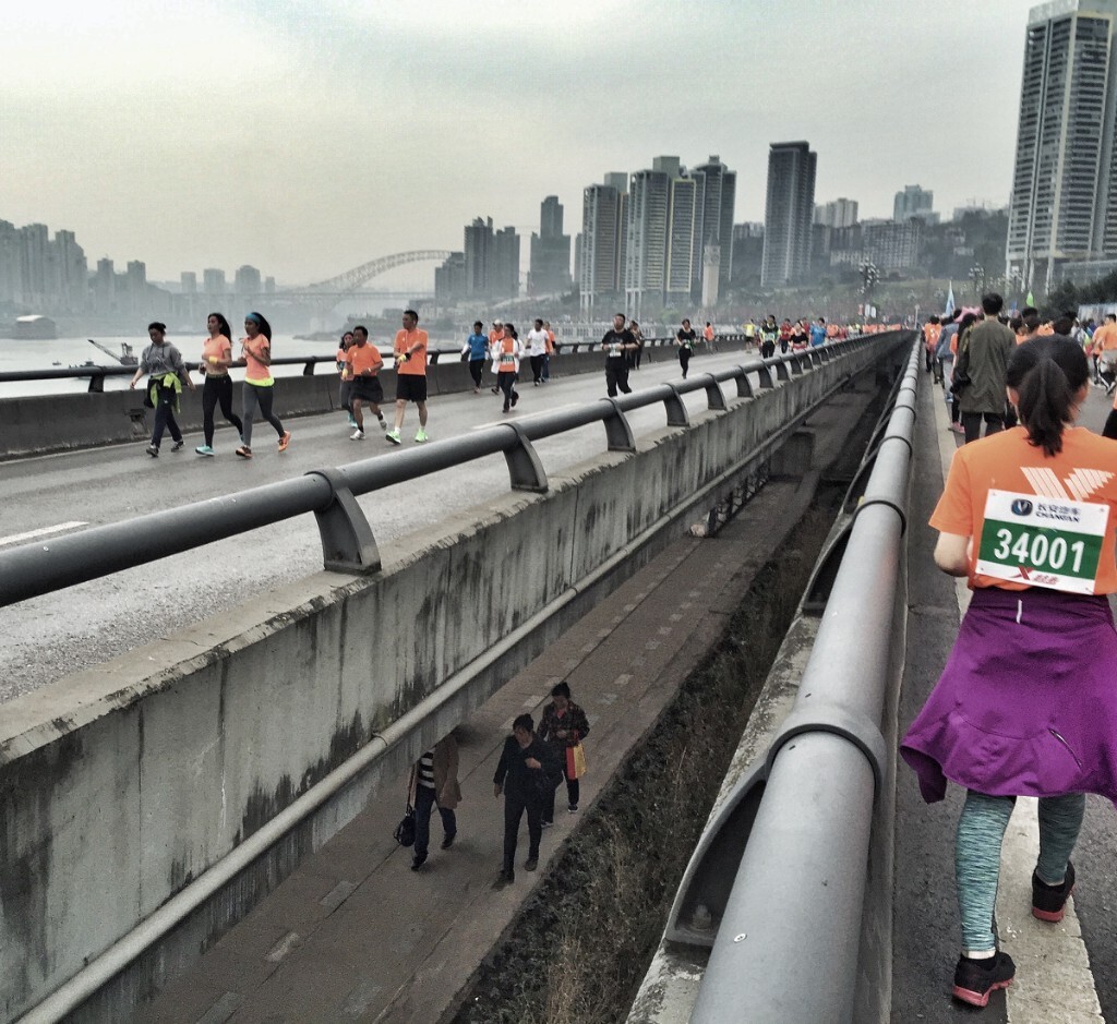 2016年3月,南岸区南滨路,参加“重庆马拉松”赛事的选手在上,闲庭信步的过路市民在下。高低起伏的地形,让重庆城形成了很多这样的缝隙。