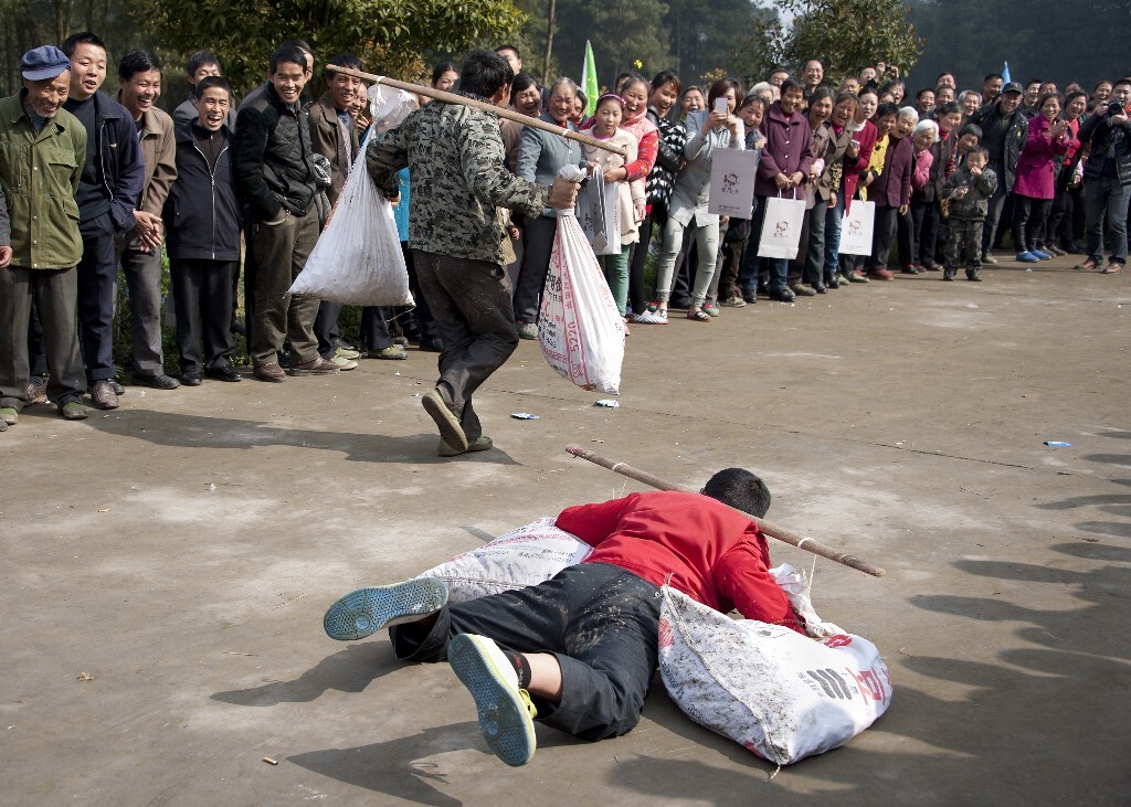 2015年3月21日,庆龙村挑粮竞走比赛中一位摔倒的选手眼睁睁地看着别人超过自已。