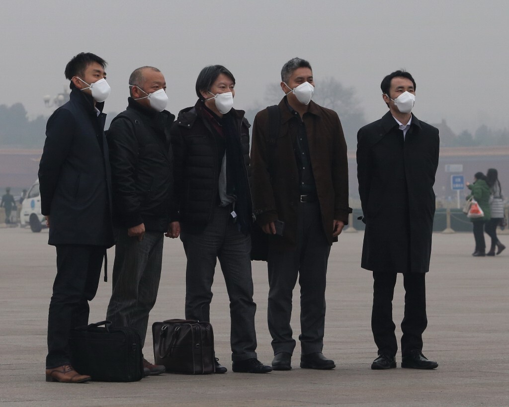 2015年12月8日,在天安门广场戴着口罩的游客。当天,北京首次发布空气重污染红色预警。