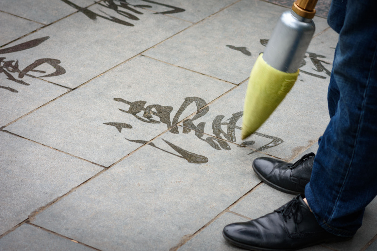 《信笔拈来》  在人民公园偶然遇见一位蘸水写字的大叔,立刻被笔下