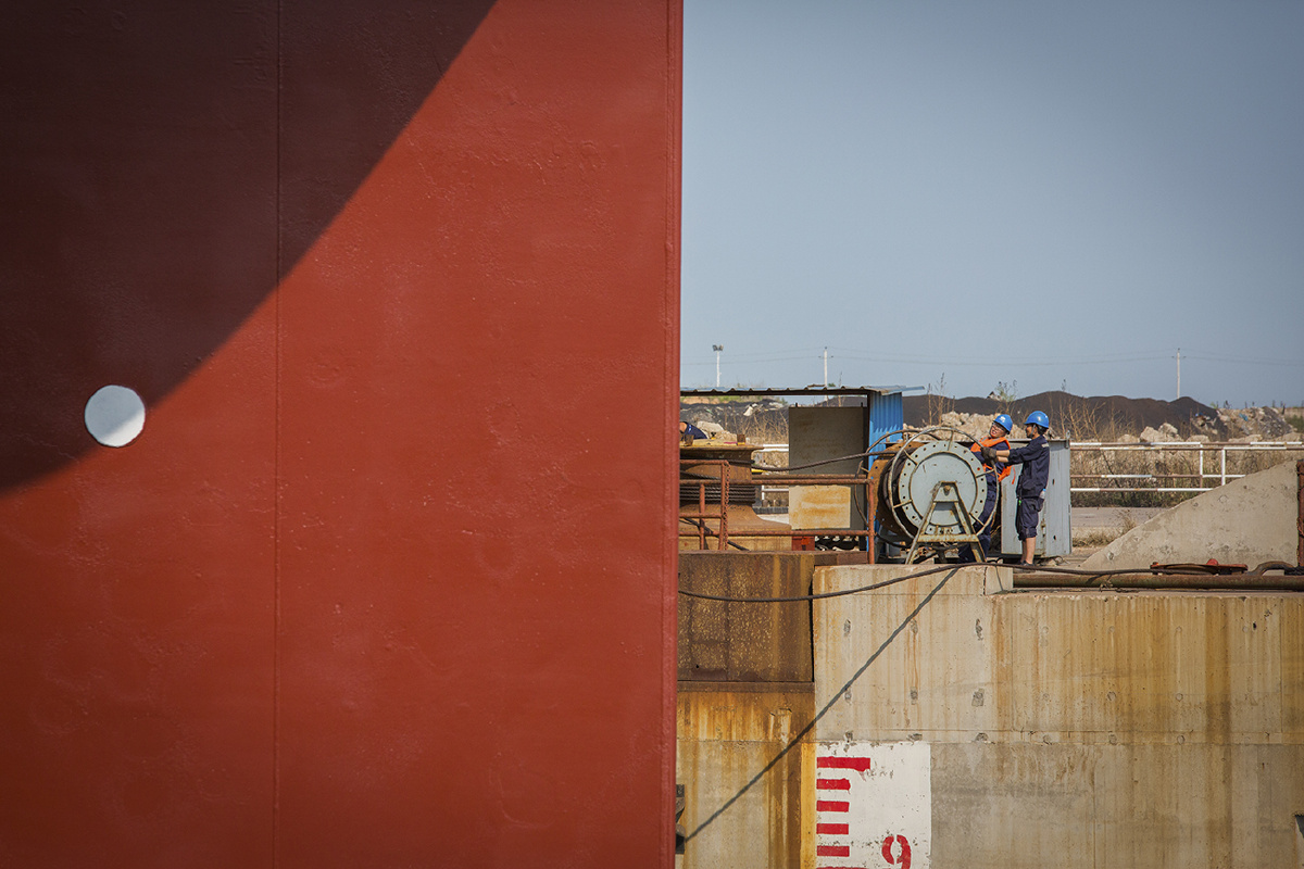 照片拍摄于河北省秦皇岛市山海关造船厂,表现了工人们对船体修护保养