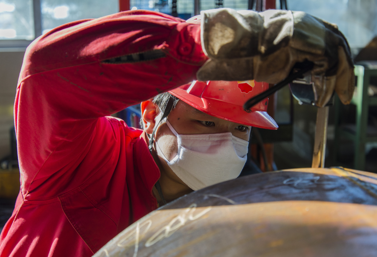 输油输气管道制造现场,表现了工人认真工作的场景