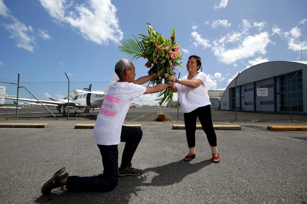 2015年12月8日,澳大利亚昆士兰州,凯恩斯Skydive Cairns 机场。父亲手捧野花向母亲“求婚”。这天是父母结婚50周年纪念日,父亲一大早就到野外采摘了很多野花。父亲说:年轻的时候,家里穷,没有给母亲像样的婚礼,今天要重新向母亲求一次婚。现在年轻人结婚都喜欢送花,我也要浪漫一次。父亲向多母亲“求婚”后,用从1万4000英尺的高空跳伞的方式来庆祝他们的金婚。