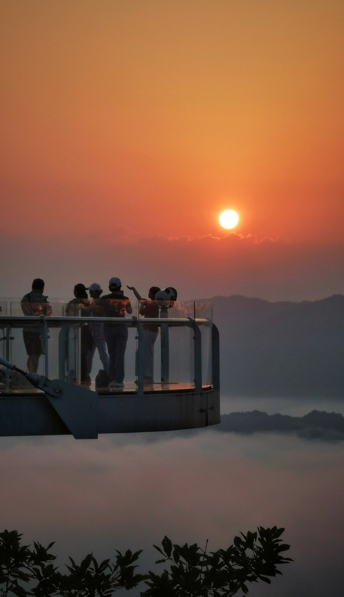 在悬空玻璃观景台上守望日出