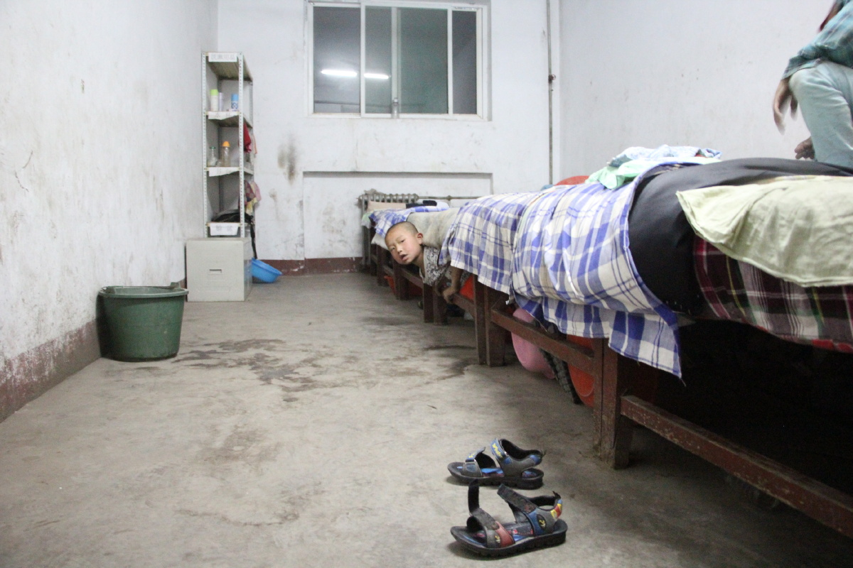 在宿舍的床底下玩捉迷藏的孩子.