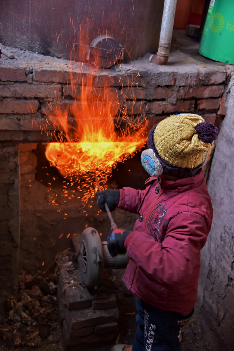 随着煤炭的加入,火焰瞬间喷出,红红的火苗映照着小云贺的脸庞,未来的