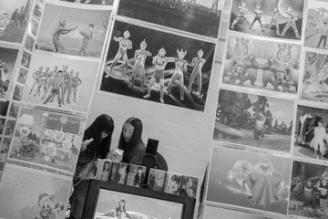 042  2015年8年，云南鹤庆，县城，物资交流会上零时照相棚里女孩们在手机上查看刚拍摄好的照片。