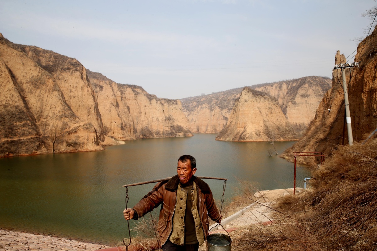 徐文海正在水库挑水,全家生活用水,全得靠这个水库.