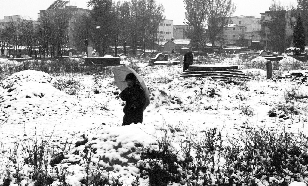 一个人踏过大雪后的坟地去上学