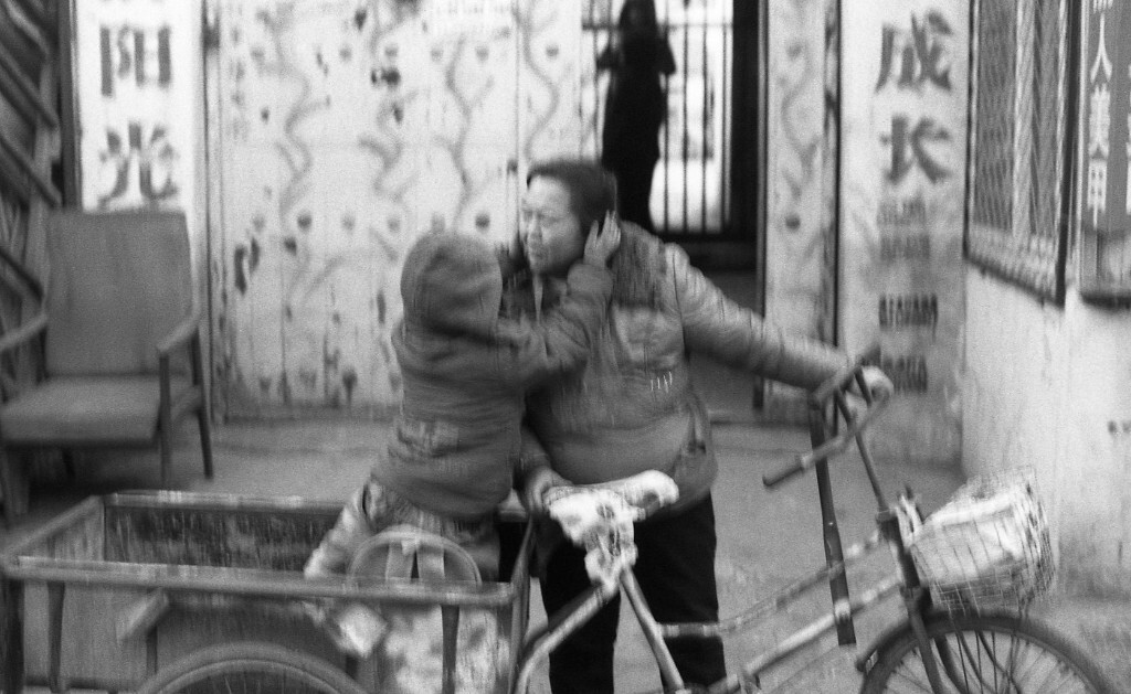 幼儿园放学接孩子的大姐，孩子从门口激动的冲了出来，一下子就窜上了三轮车，然后摸了摸妈妈的脸亲了一口。我当时正好路过，反应迟钝了，抬起相机拍了一张，结果遗憾的拍虚了。但是当时的情景令我很难忘。