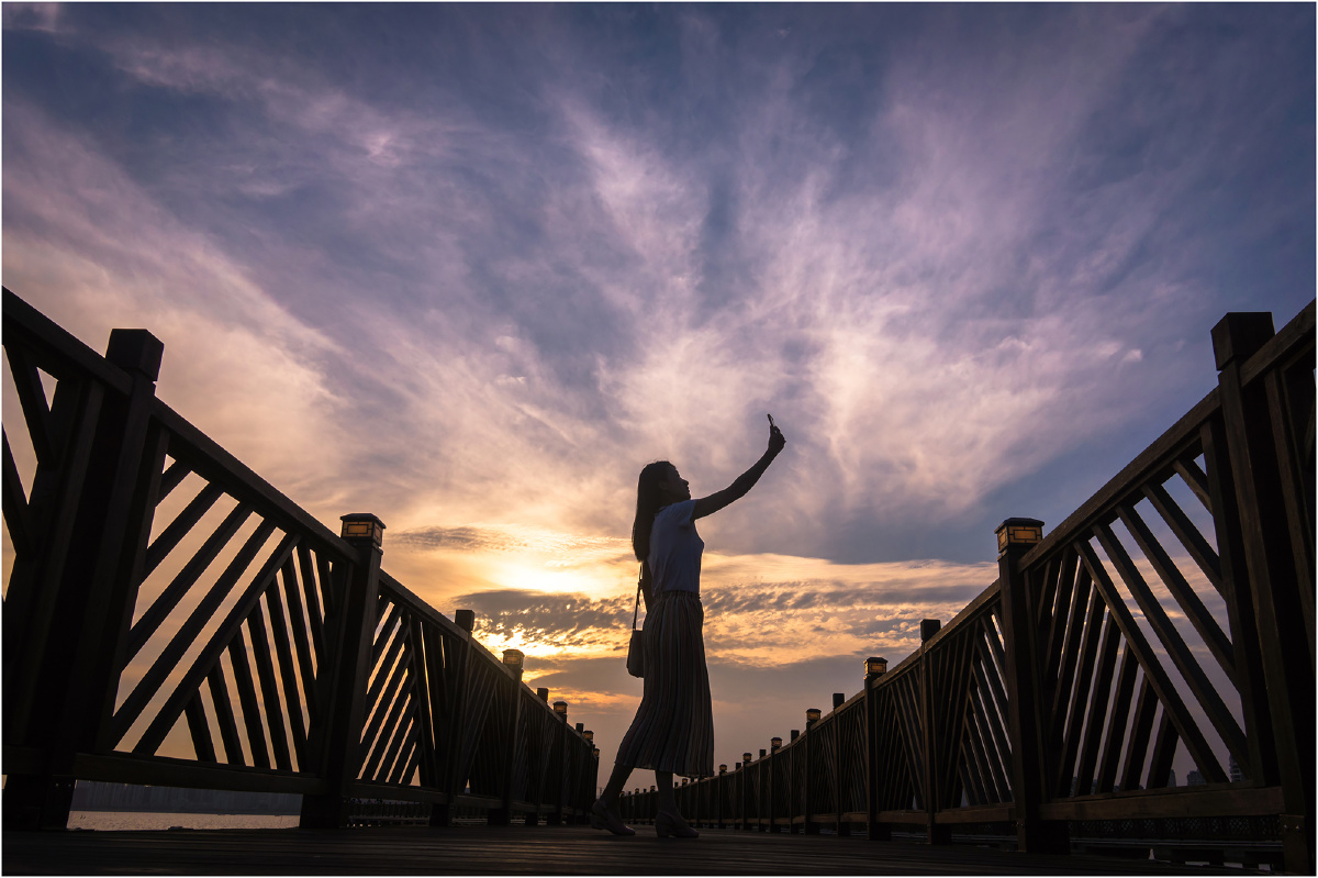 黄昏晚霞中自拍的女人