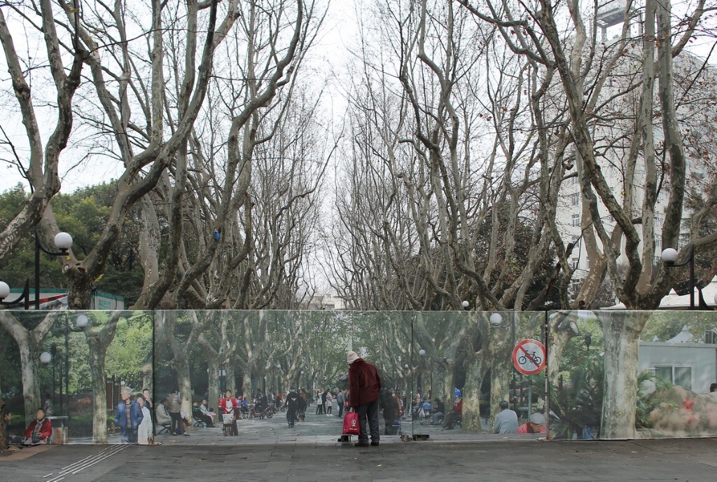 上海，一正在改造的公园大门用原大门处拍摄的实景照片做围墙，真实与虚幻中让人一瞬间恍然产生了错觉。