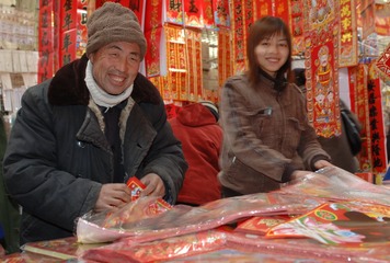 辽宁锦州2005年12月25日父亲和女儿一起卖对联因为地少，只能做小买卖收入还行