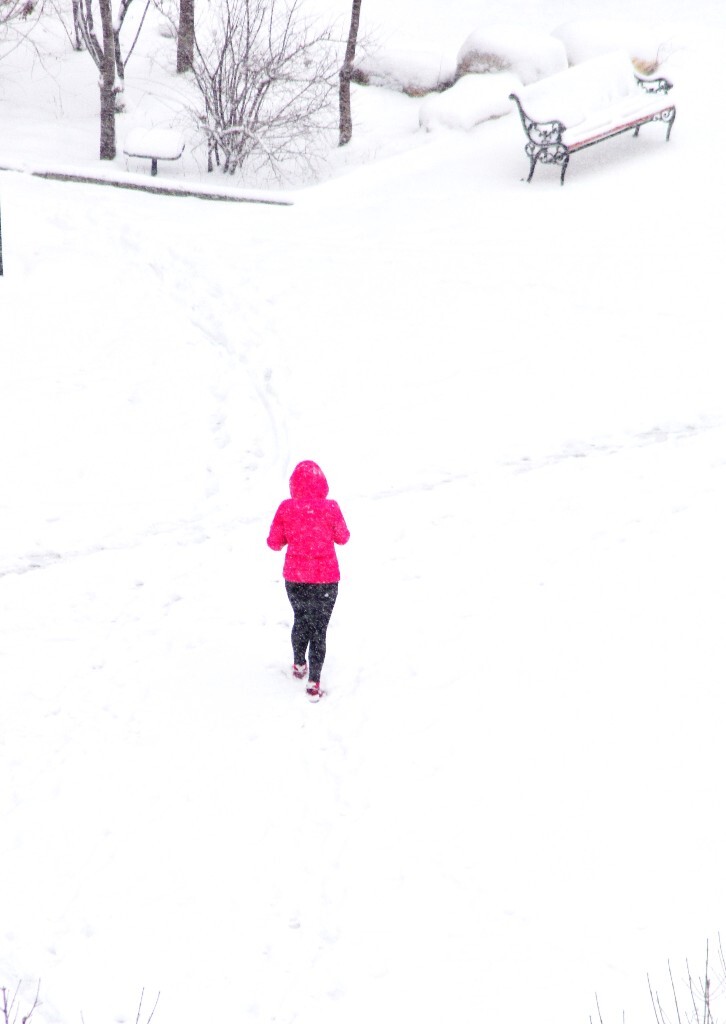 在茫茫大雪中行色匆匆的红衣路人