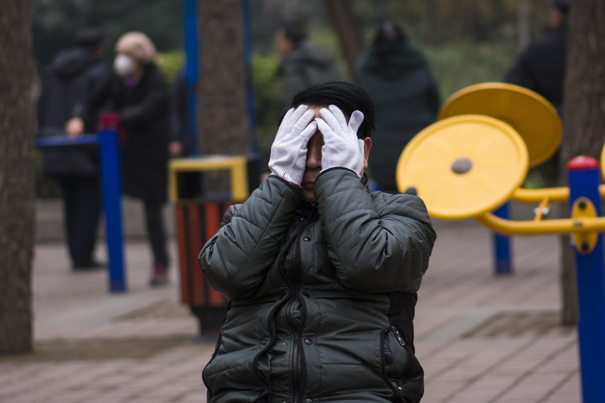 一位老人正在蒙头晨练.