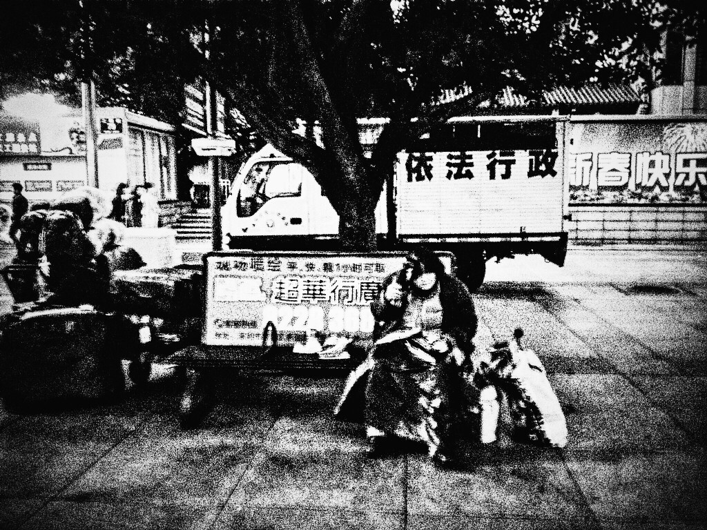 在一处广场上她拿着一空瓶子左右摇摆，旁边还有几个袋子装了很多！