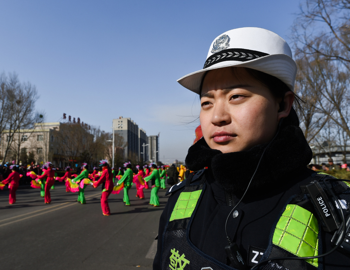 整条街有很多警察,此女警察忠于职守,表情严肃.