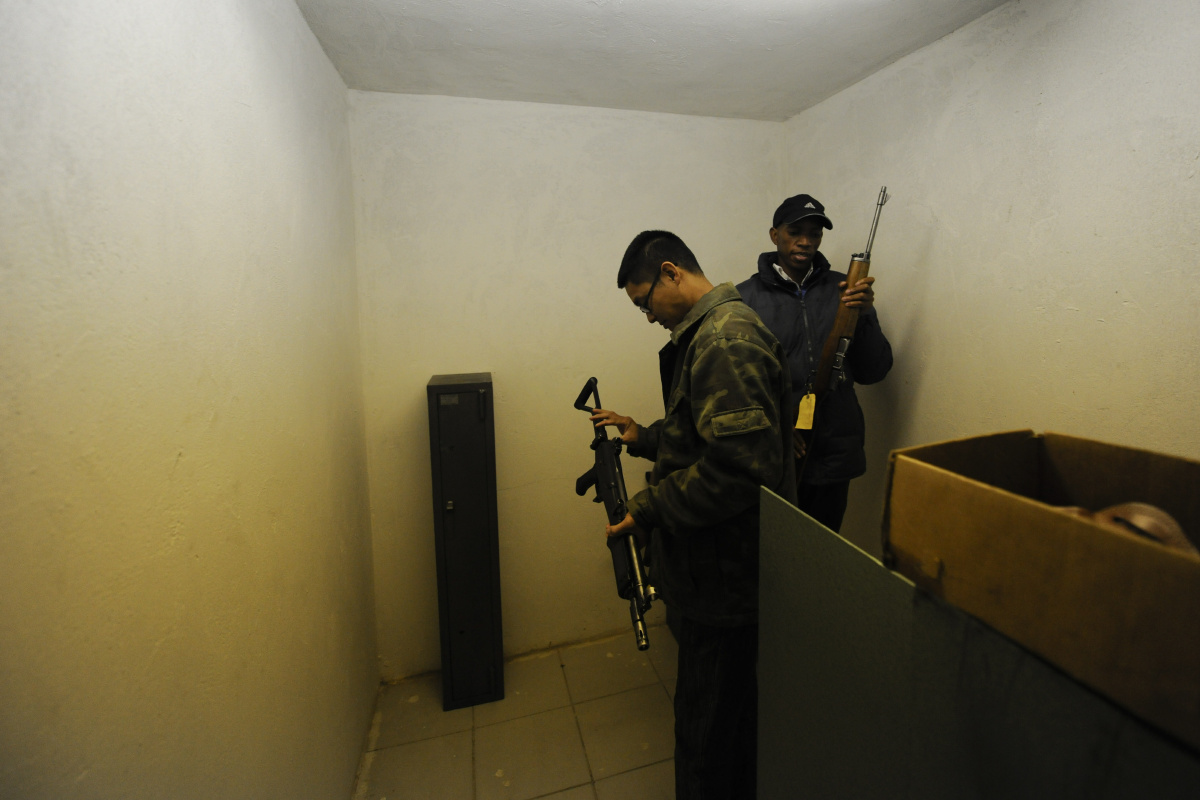 约翰内斯堡,南非华人安保公司总经理谢宇航和职员在公司枪库中取枪械