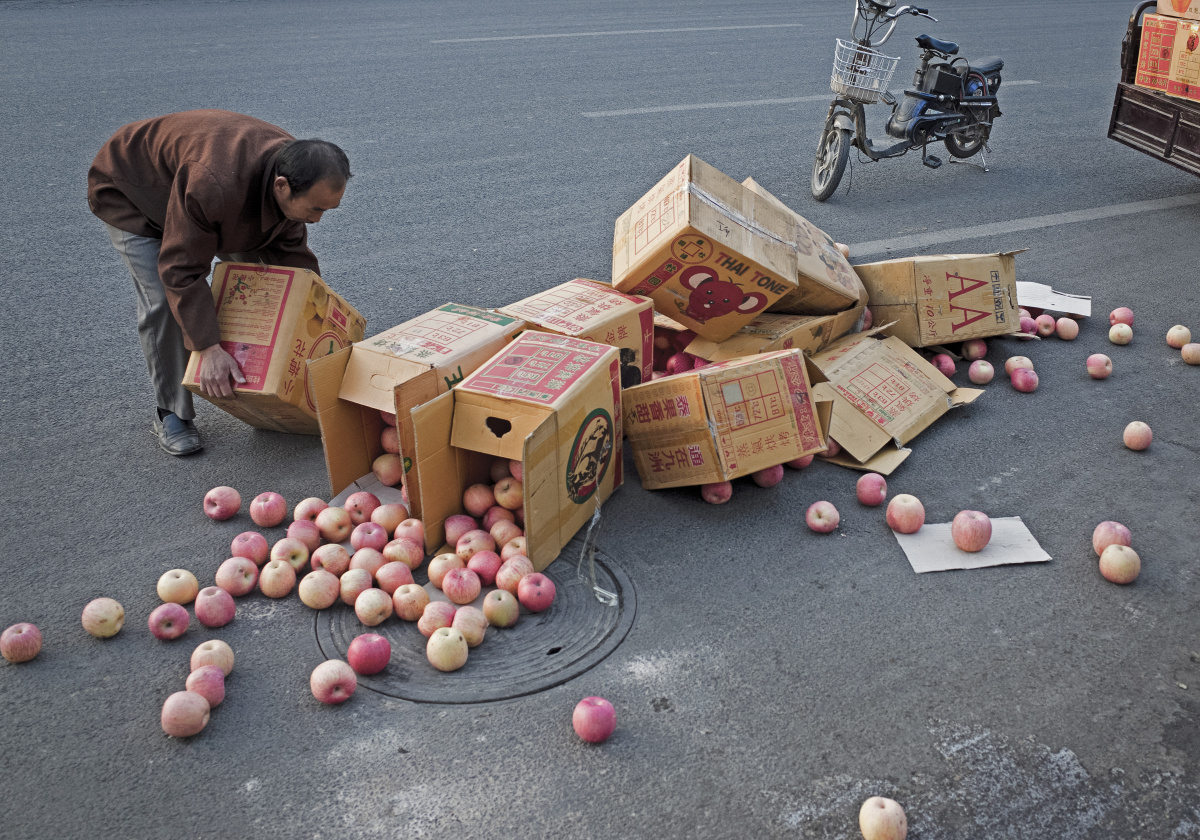 图02:2014年10月7日,山东济南,一位生意人拾到不慎洒落一地苹果.