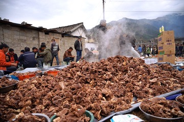 堆得像小山一样的肉，就这样码放在野地上。家境稍好后人发达的人家，举办丧事打牛十余头司空见惯，并且搭配相对数量的猪和羊。这样的奢侈和铺张受到政府移风易俗的干预，但行政干预往往鞭长莫及，无法深入到山寨的每一个角落，无法透过家族亲情筑起的铜墙铁壁。