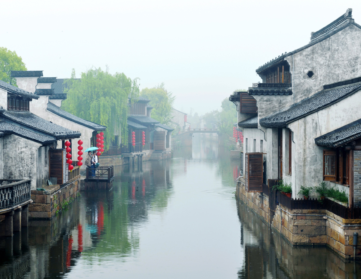 4月的江南,烟雨蒙蒙,两位游客在北仓河的岸边欣赏着江南水乡的朦胧美.