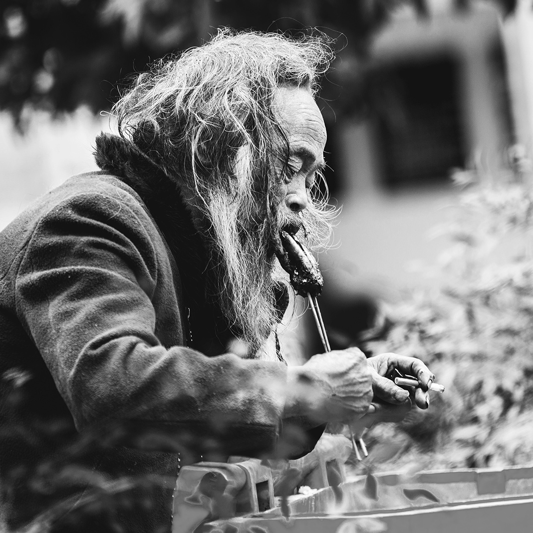 《别样人生》系列之一,流浪老人正在吃垃圾箱里人们丢失的食物.