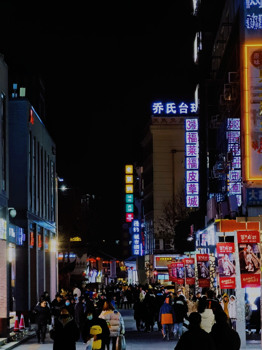 熙攘的人群夜晚的街道灯光下的小店