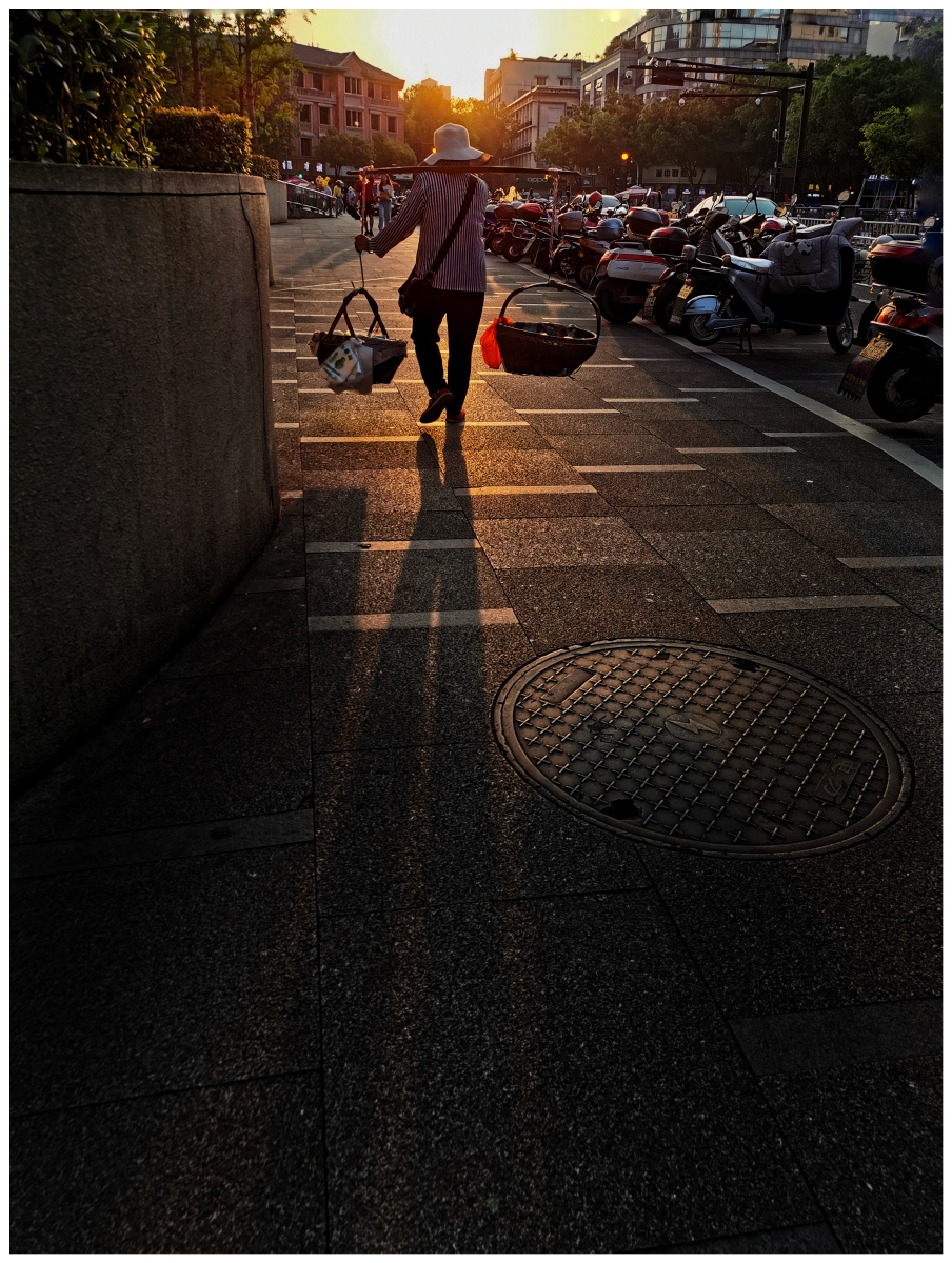 03的傍晚,走在我前面的50多岁的妇女,挑着一担空蓝,满意的边走边说