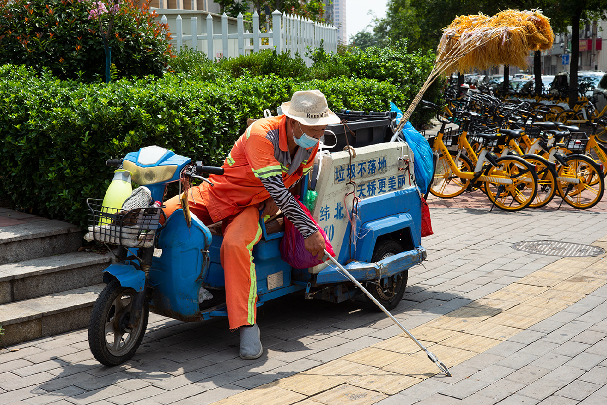《烈日下捡拾烟头的老人》2021年7月25日,济南馆驿