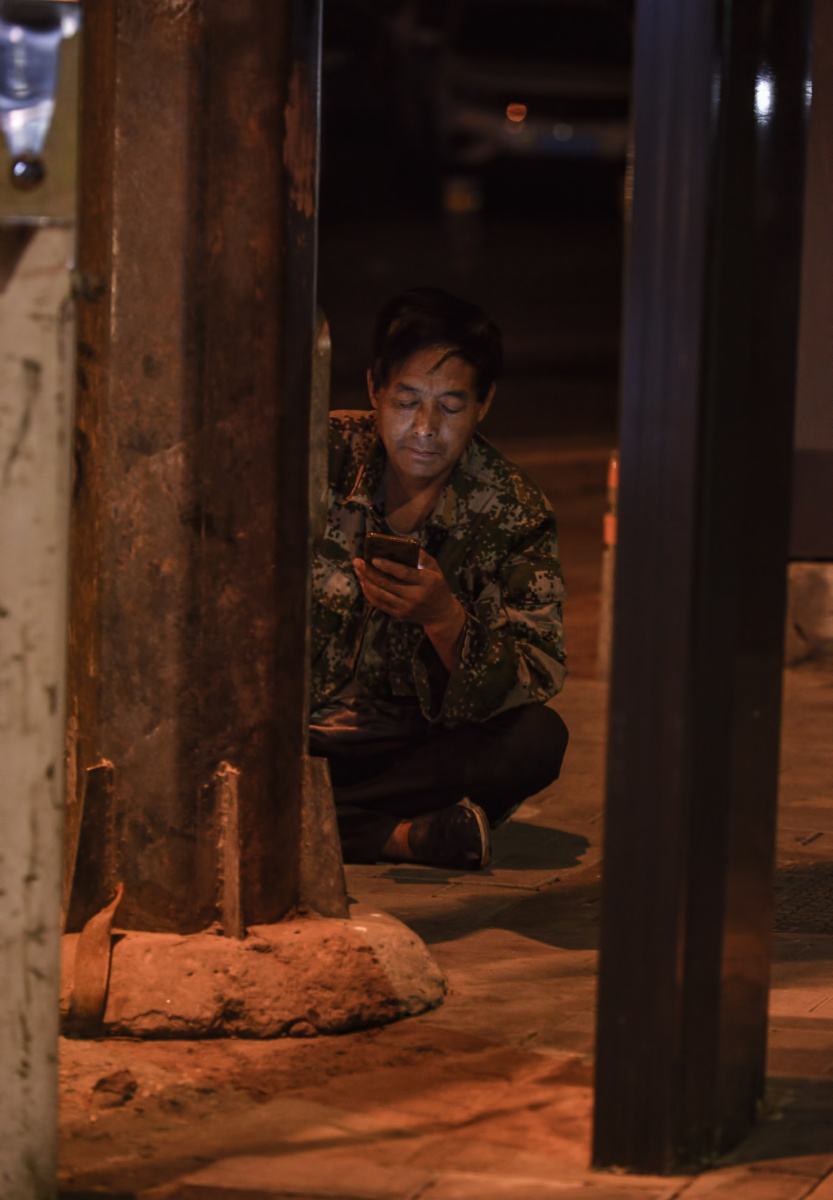 夜幕下身穿迷彩服的一位农民工不知白天是否找到了活路在别人都已回家