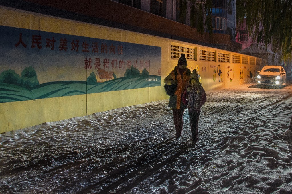 《《爱之光》晚上下雪天一辆汽车为了行人安全在后面慢慢开着给行人照路。很感人。拍下来这个瞬间。