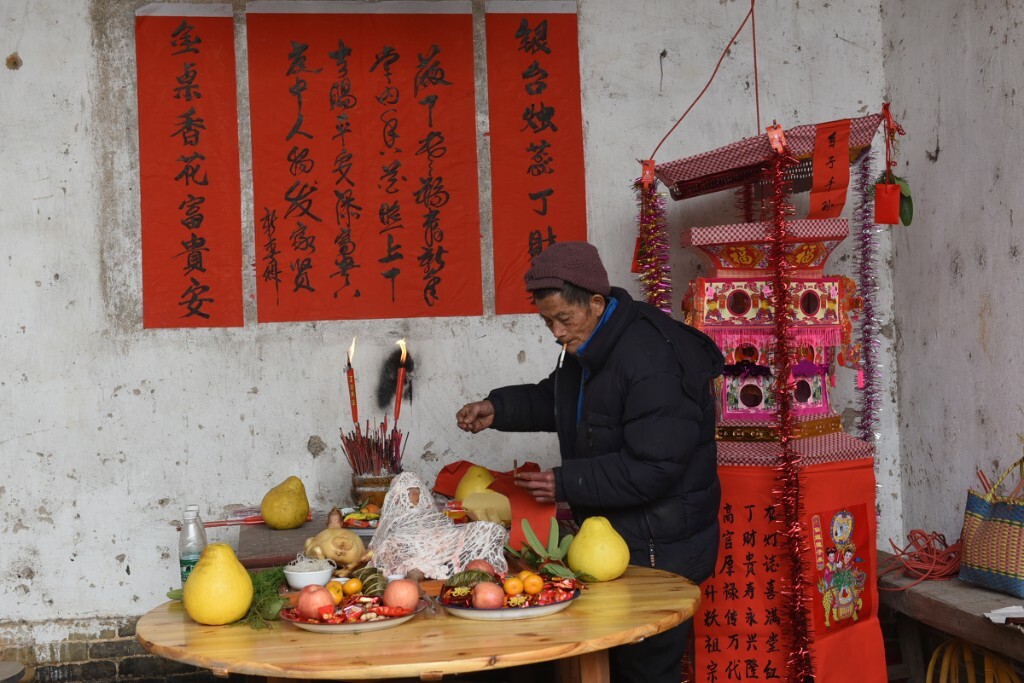 龙府添丁,孩子的祖父正从老屋厅堂准备为他的曾孙上灯祈福。