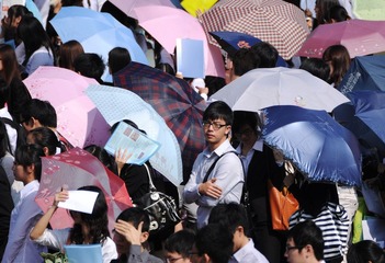 11月20日暨南大学文科专场招聘会，烈日下，伞丛中，一名男生在无奈地等待.JPG