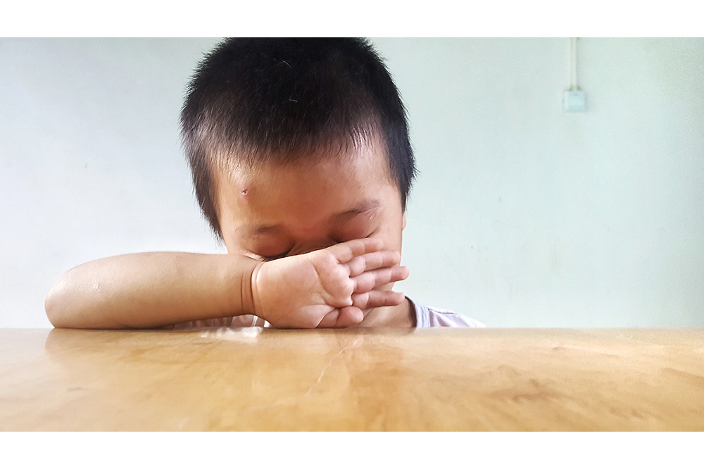 4,刚入学的小孩子,还不适应校园生活,奶奶离开后,自己用小手擦着眼泪.