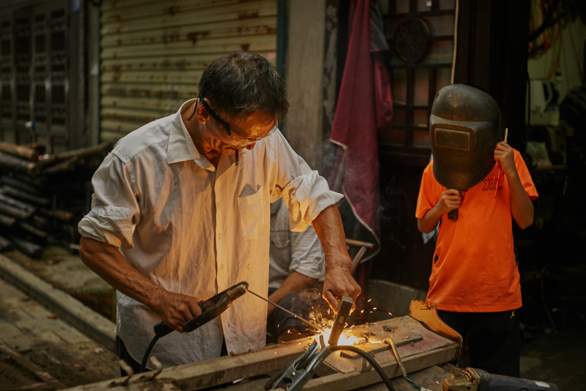 小学徒在跟老师傅学手艺.
