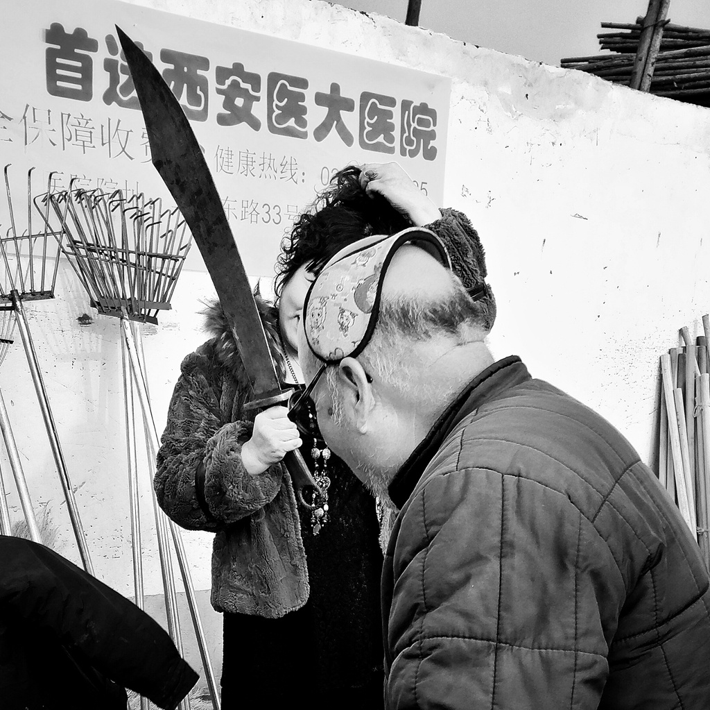 一位女士正在举刀拍纪念照,我按下快门的瞬间一位大爷的脑袋闯了进来!