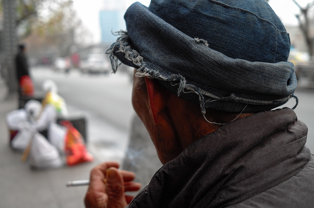 一进城老人在焦急等待公交到来.2016年1月8日拍于金华.