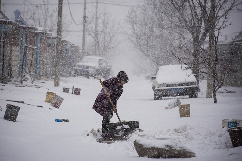 雪中村景2020214大雪纷飞一村民正在清理街道上的积雪
