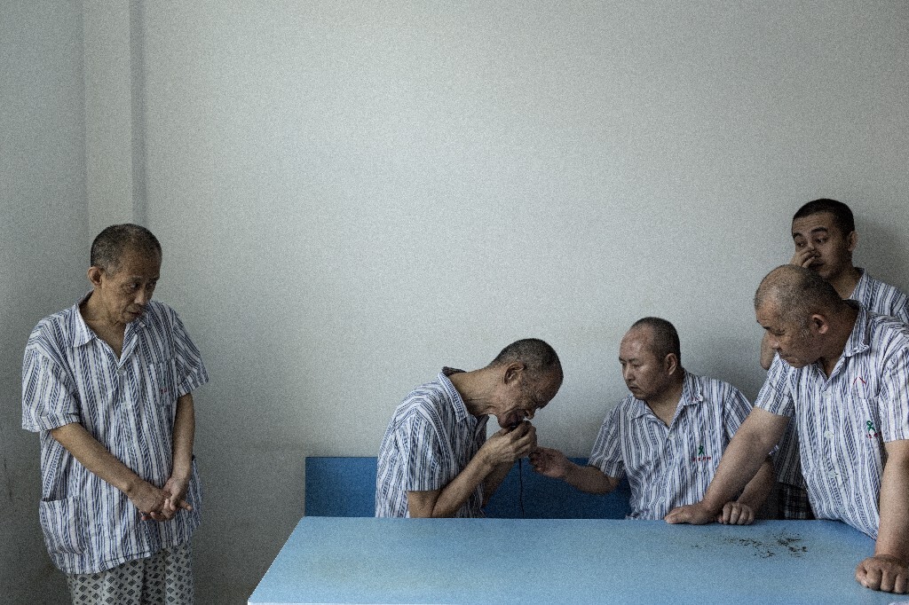2014年8月,北大荒知青安养中心,几个男患者围在一起等待使用剃须刀刮胡子。