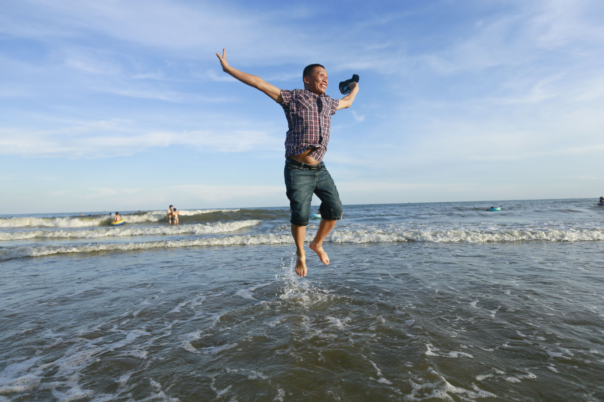 大海边,兴奋跳起的男子.