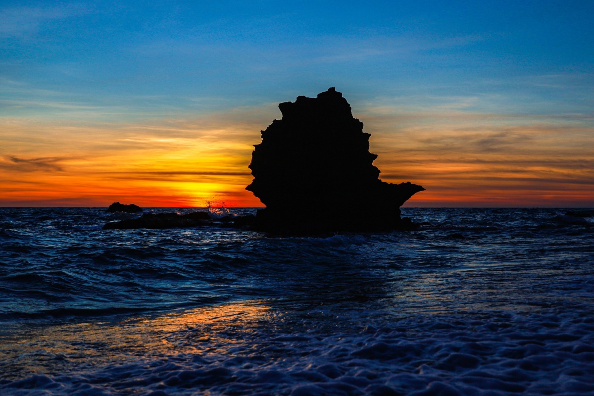 龙门激浪的一块风化的火山岩石,屹立在汹涌澎湃的海浪形状像帆船石