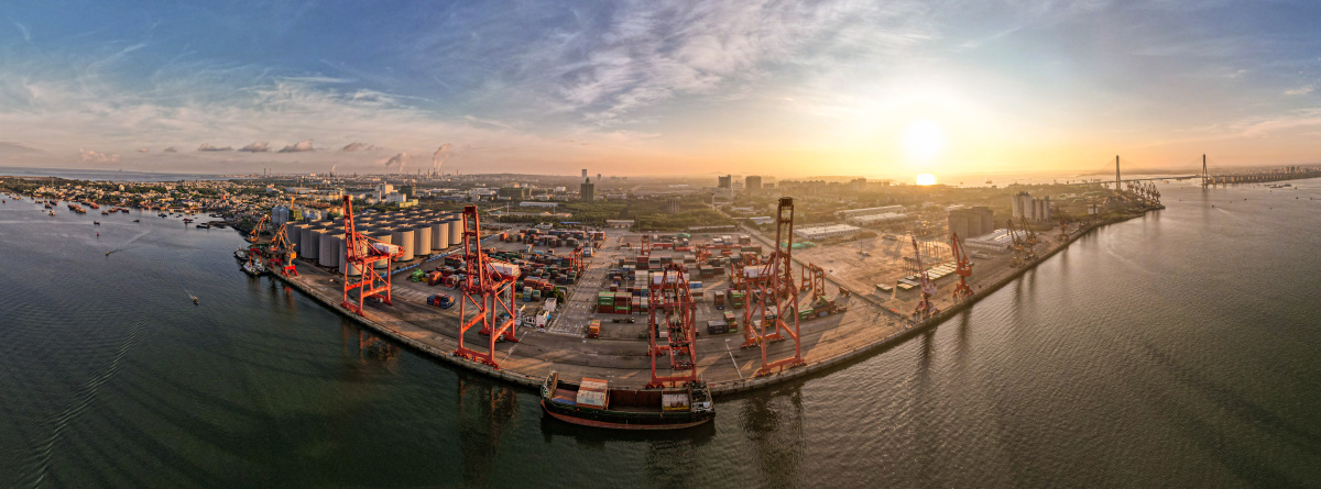 航拍日出前的集装箱码头已经在给巨轮装卸货物了